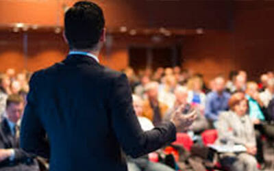 Business executive speaking at a business conference, convention or seminar for Go Luxe Corporate Transportation